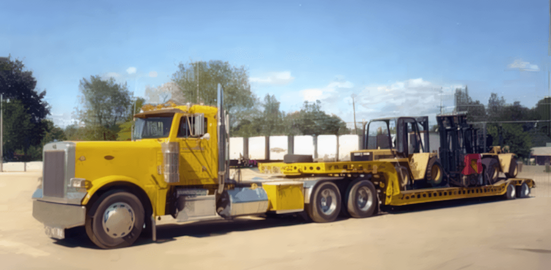 A yellow Muse Trucking truck hauling heavy machinery