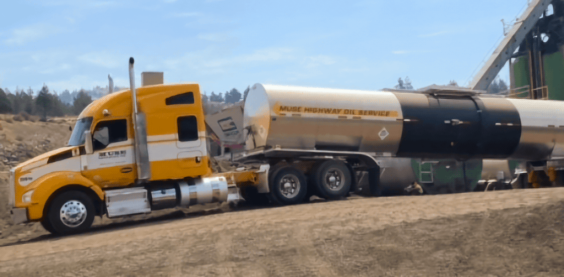 A yellow Muse Trucking truck hauling an oil tank